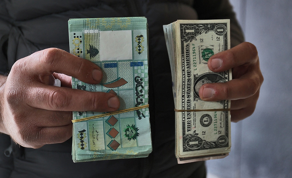 BEIRUT: A black-market currency dealer holds US dollars and Lebanese pounds on March 14, 2023. - AFP