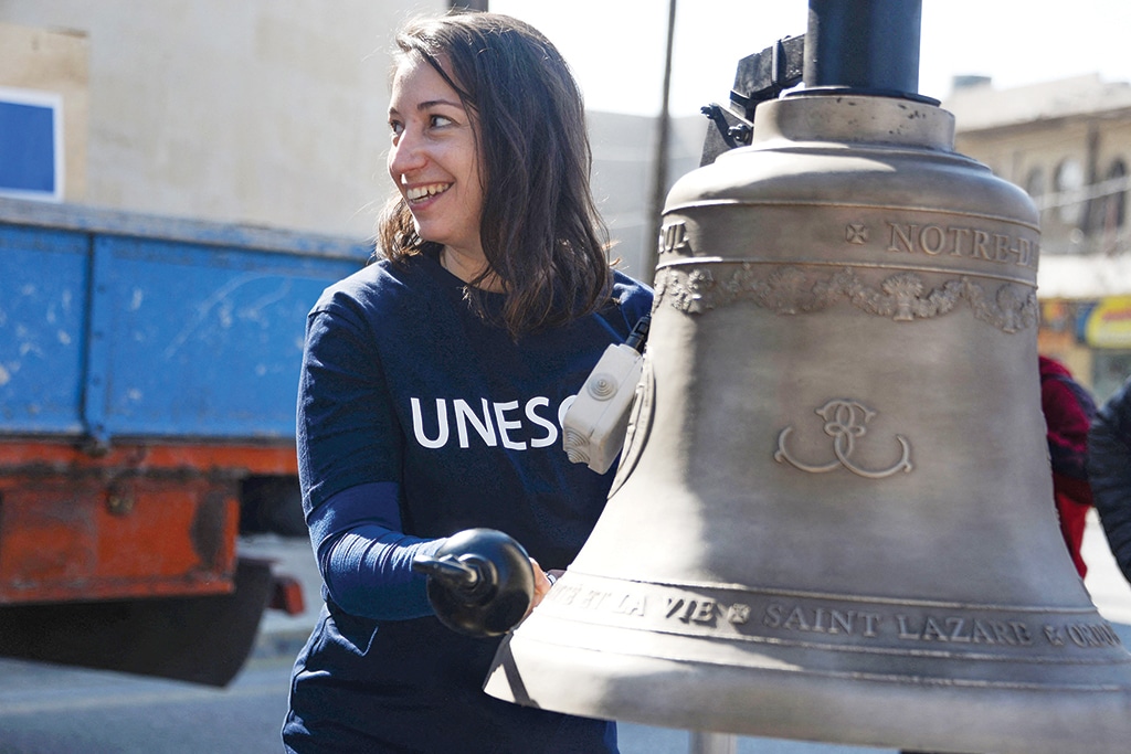 MOSUL : A woman poses next to one of three bells cast in Normandy as they are prepared for installation on February 28, 2023 in the bell tower of the historic Roman Catholic Dominican Church of Our lady of the Hour in Mosul, a metropolis in northern Iraq where heritage jewels are being rebuilt after the abuses of the jihadist group Islamic State (IS).— AFP