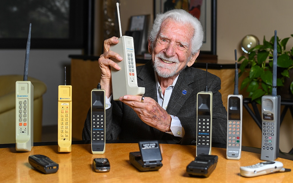 DEL MAR,US: Engineer Martin Cooper holds a contemporary copy of the original cell phone he used to make the first cell phone call on April 3, 1973, in Del Mar, California on March 20, 2023. – AFP