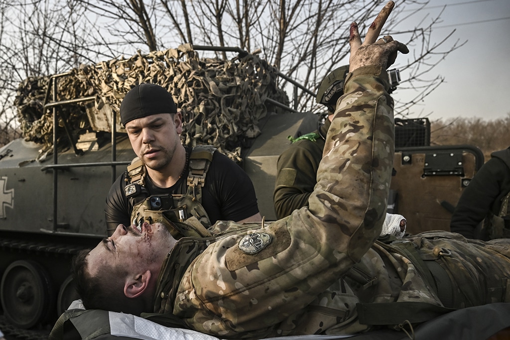 BAKHMUT: A wounded Ukrainian serviceman flashes the V-sign as he is being carried away from the frontnline near Bakhmut, on March 23, 2023. – AFP