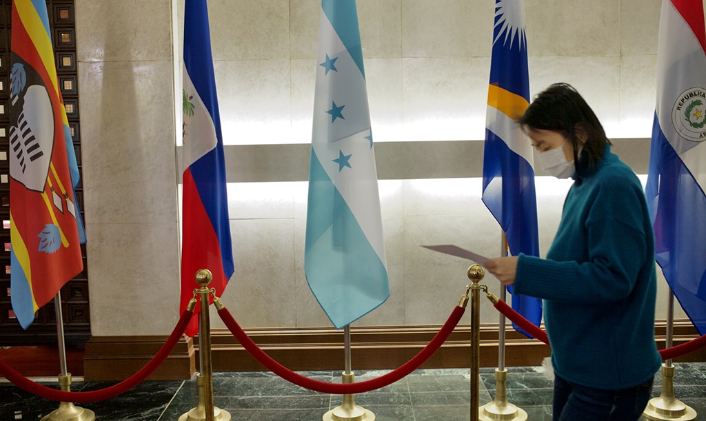 TAIPEI: File photo shows, a woman walks past a Honduras flag (C) at Taiwan’s Ministry of Foreign Affairs in Taipei. Taiwan recalled on March 23, 2023 its ambassador to Honduras over a visit by Tegucigalpa's foreign minister to China, Taipei's government said in a statement. – AFP