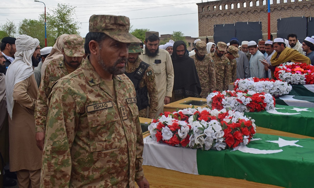 LAKKI MARWAT: Relatives and security officials gather around the coffins of policemen who were killed by a roadside bomb in Lakki Marwat district of Khyber Pakhtunkhwa province on March 30, 2023. – AFP