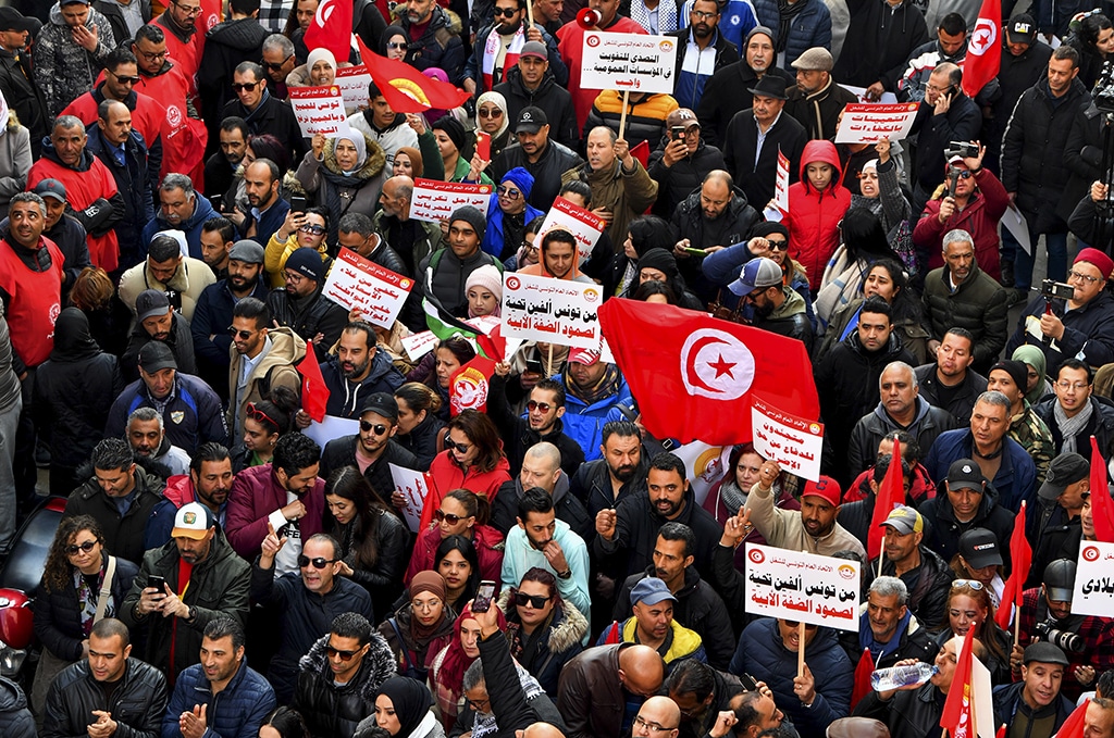 TUNIS: Demonstrators lift placards and national flags during an anti-government rally called for by the UGTT union. - AFP