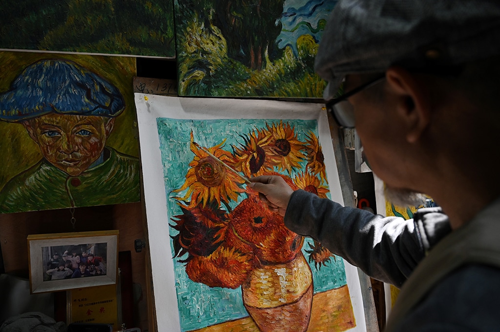 This picture taken on February 19, 2023 shows artist Deng Fei painting a replica of Vincent van Gogh’s “Sunflowers” in an alley at Dafen village, in Shenzhen, in China’s southern Guangdong province. — AFP photos