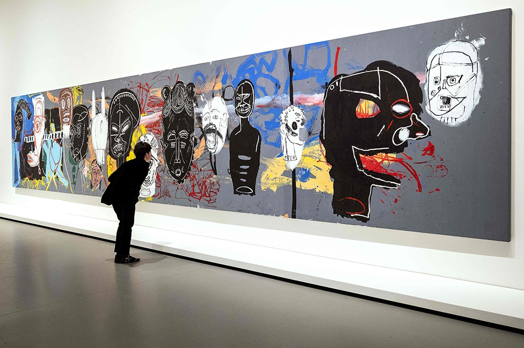 A visitor looks at “Arican Masks”, an acrylic painting. — AFP photos