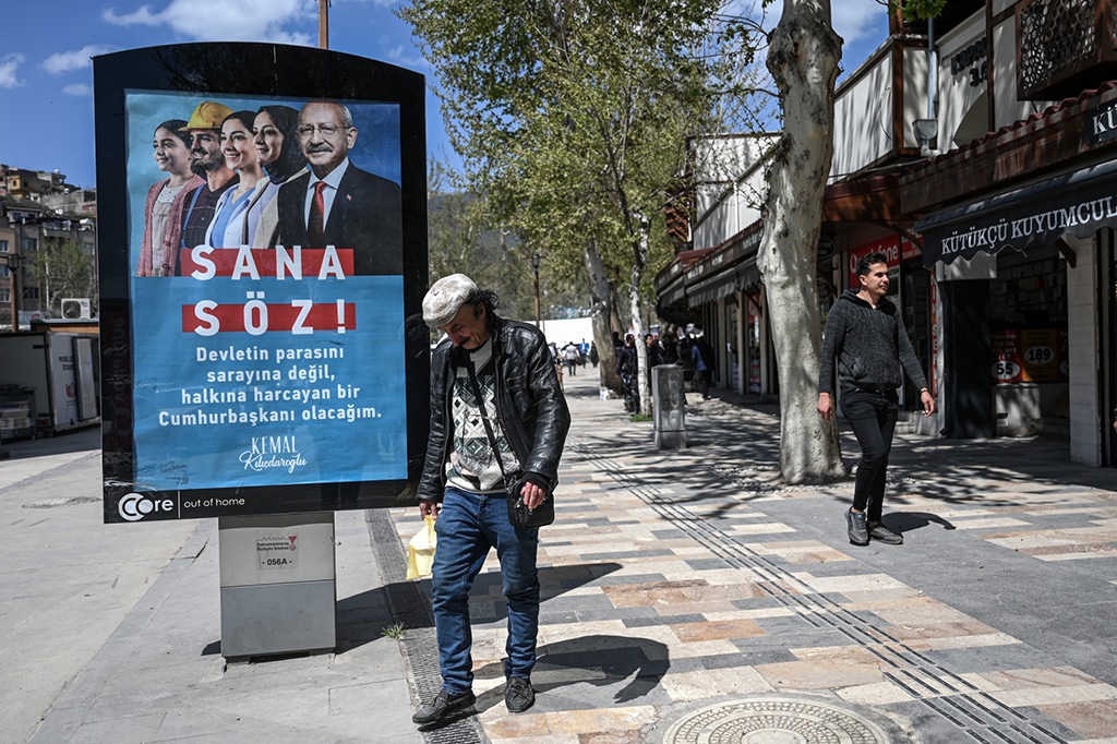 KAHRAMANMARAS:  A man walks past an electoral poster of Turkey's Republican People's Party (CHP) in the quake-hit city of Kahramanmaras on April 4, 2023, two months after the 7.8 magnitude devastating earthquake of February 6. – AFP