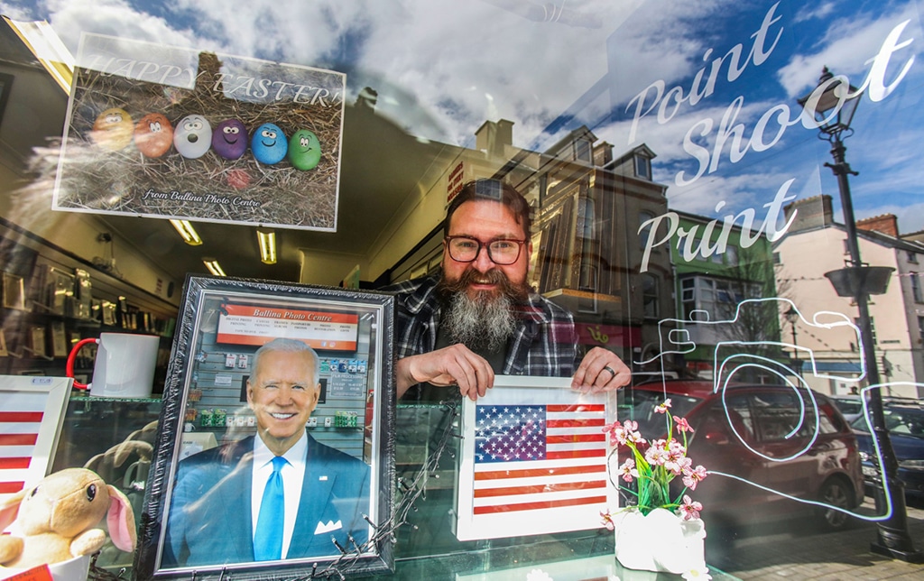 BALLINA: Derek Furlong poses in the window of his Ballina photo centre, as he and others dress up their business properties in Ballina town centre as the town prepares to welcome President Biden to the town in Co Mayo, the his ancestral home. – AFP
