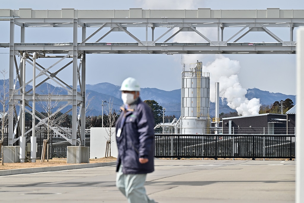 NAMIE: In this file photo taken on February 15, 2023 a worker walks at the 'Fukushima Hydrogen Energy Research Field' (FH2R), one of the largest test facilities in the world producing hydrogen from renewable energy, as smoke billows from a neighboring plant. – AFP