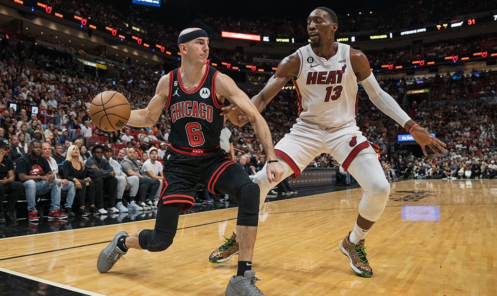 MIAMI: Alex Caruso of the Chicago Bulls passes the ball while being defended by Bam Adebayo of the Miami Heat during the second quarter at Kaseya Center on April 14, 2023. – AFP