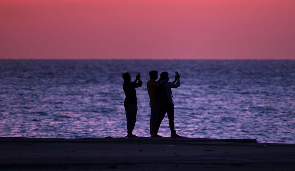 KUWAIT: Men take ‘selfie’ pictures along the beach at sunrise, in Kuwait City on April 15, 2023. With the growth of urbanization and modernization, people’s lifestyles have changed significantly. — Photos by Yasser Al-Zayyat