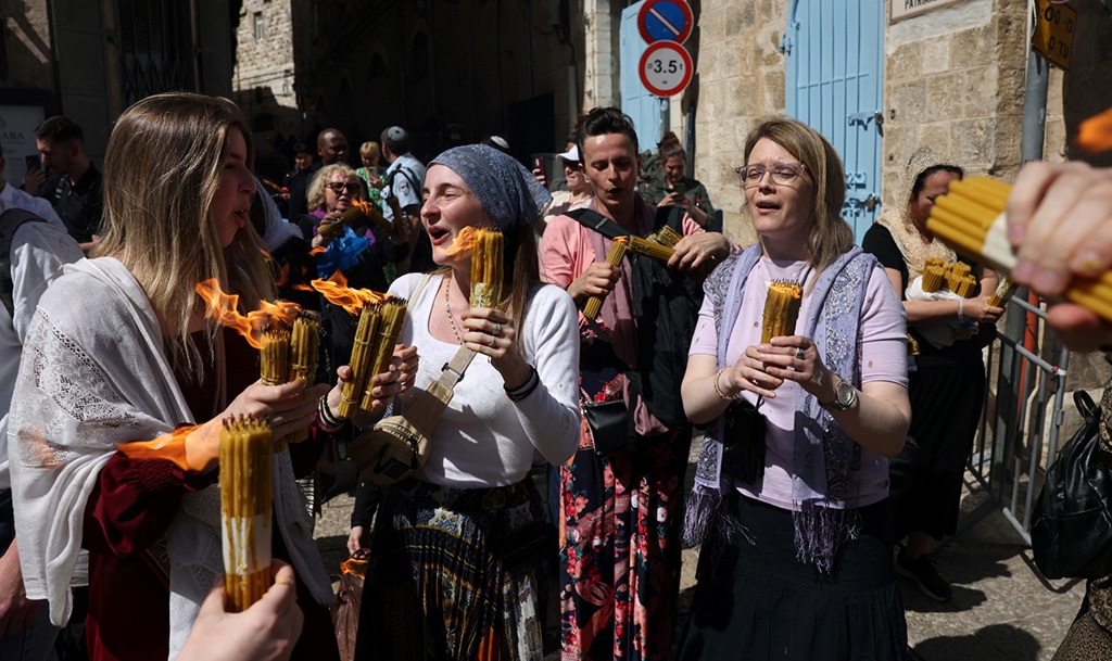 JERUSALEM: Christian worshippers carry candles lit with the ‘Holy Fire’ obtained from the Church of the Holy Sepulchre in Jerusalem, during the Orthodox Christian Easter Saturday celebrations. – AFP