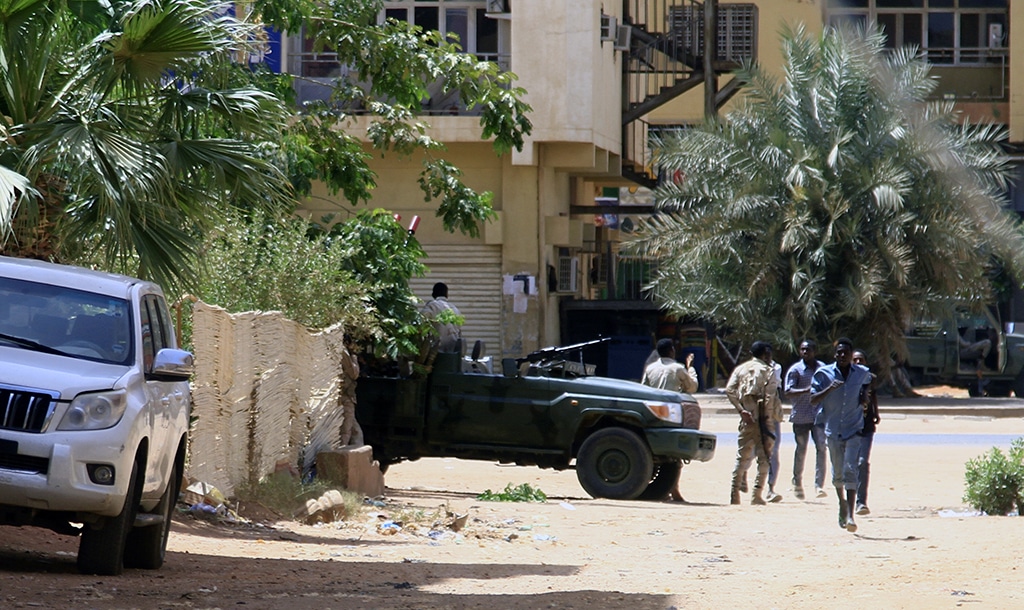 KHARTOUM: People run past a military vehicle in Khartoum amid reported clashes in the city. — AFP