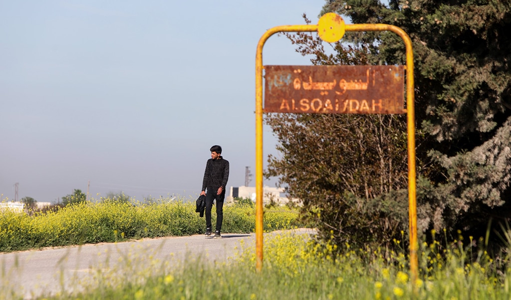 AS SUWAYDAH: A man walks past the sign of Soueida near Jarablus, in the north-east of Syria's Aleppo province, on April 17, 2023, following a US helicopter raid on an Islamic State group leader in the village. – AFP