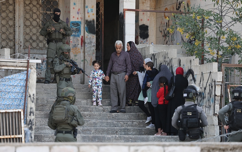JERUSALEM: A Palestinian family waits outside as Zionist security forces search for suspects following a shooting attack in the neighbourhood of Sheikh Jarrah in annexed east Jerusalem, on April 18, 2023. – AFP