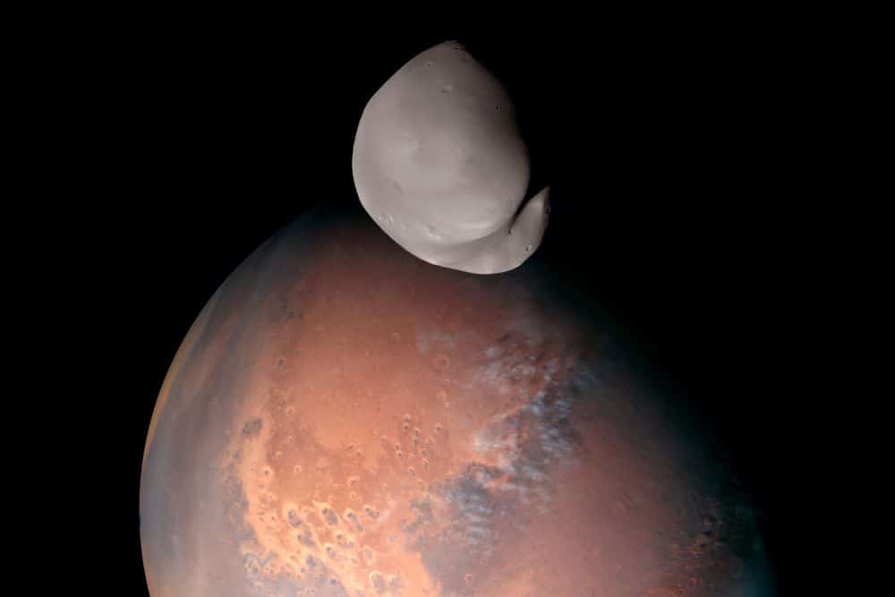 This composite image released by the Emirates Mars Mission on April 24, 2023, shows Mars’ moon Deimos in the foreground. - AFP