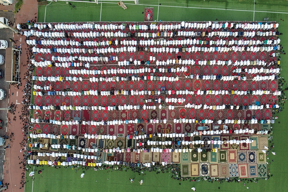 KUWAIT: In this aerial view, Muslim worshippers pray on the first day of Eid Al-Fitr, which marks the end of the holy fasting month of Ramadan, at a football stadium in Kuwait City on April 21, 2023. —Photo by Yasser Al-Zayyat