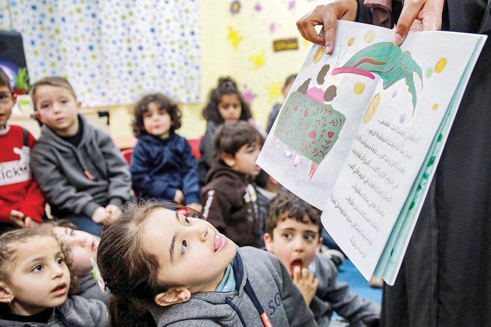 In this picture Jordanian teacher Huda Abu Al-Khair (right) reads stories to children in a classroom in Amman.—AFP photos