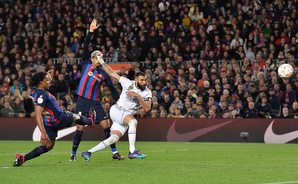 BARCELONA: Real Madrid’s French forward Karim Benzema  kicks the ball and scores his team’s fourth goal during the Copa del Rey (King’s Cup) semi-final second leg football match between FC Barcelona and Real Madrid CF at the Camp Nou stadium in Barcelona. – AFP