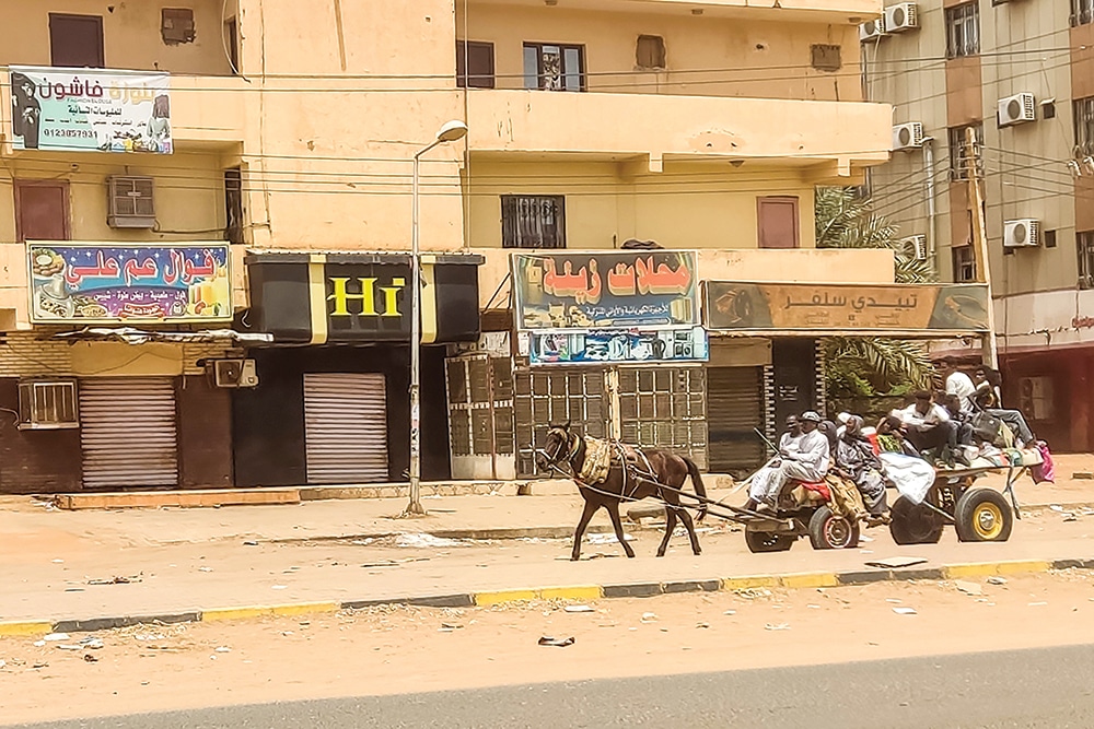 KHARTOUM: People travel on a horse-drawn wagon along a street as fighting continues in Khartoum on April 28, 2023. Residents desperately count their last banknotes as nearly two weeks of fighting has frozen cash sources and pushed an already faltering financial system to the brink. -- AFP
