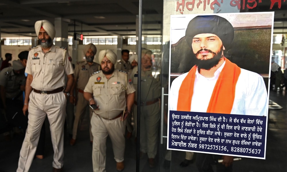 In this file photo taken on April 13, 2023, police stick Amritpal Singh's poster at a railway station in Amritsar. Firebrand fugitive Sikh separatist Amritpal Singh has been arrested after a massive manhunt that lasted more than a month, Indian police said on April 23.