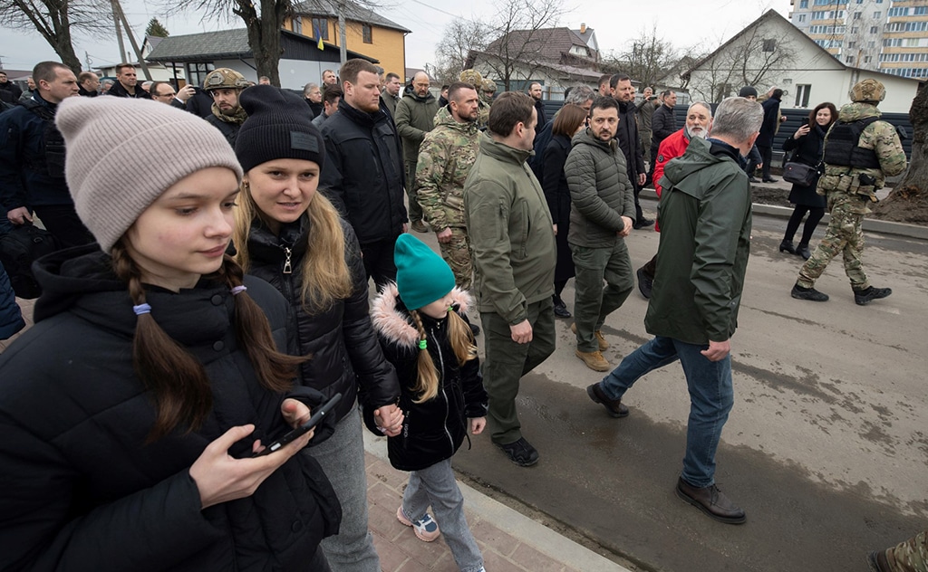 BUCHA: Handout picture shows Ukraine’s President Volodymyr Zelensky (C), walking in a restored street, as part of a visit to mark the first anniversary of the retreat of Russian troops from the Ukrainian town of Bucha, in Bucha, near Kyiv. — AFP