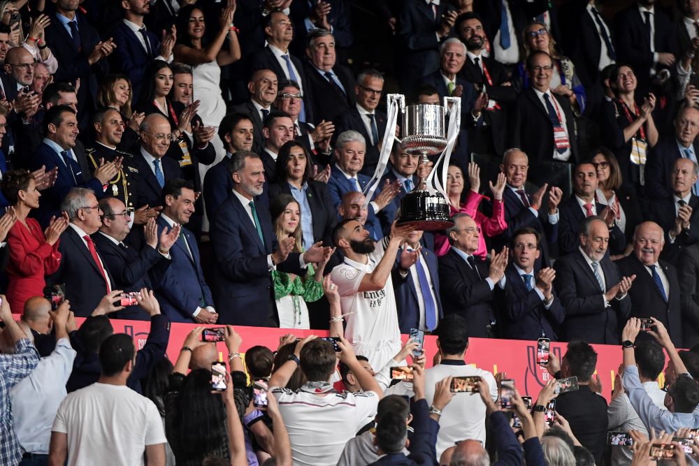 Seville: Real Madrid's French forward Karim Benzema (C) poses for pictures holding the trophy next to King Felipe VI of Spain after winning the Spanish Copa del Rey (King's Cup) final football match between Real Madrid CF and CA Osasuna at La Cartuja stadium in Seville on May 6, 2023. - AFP