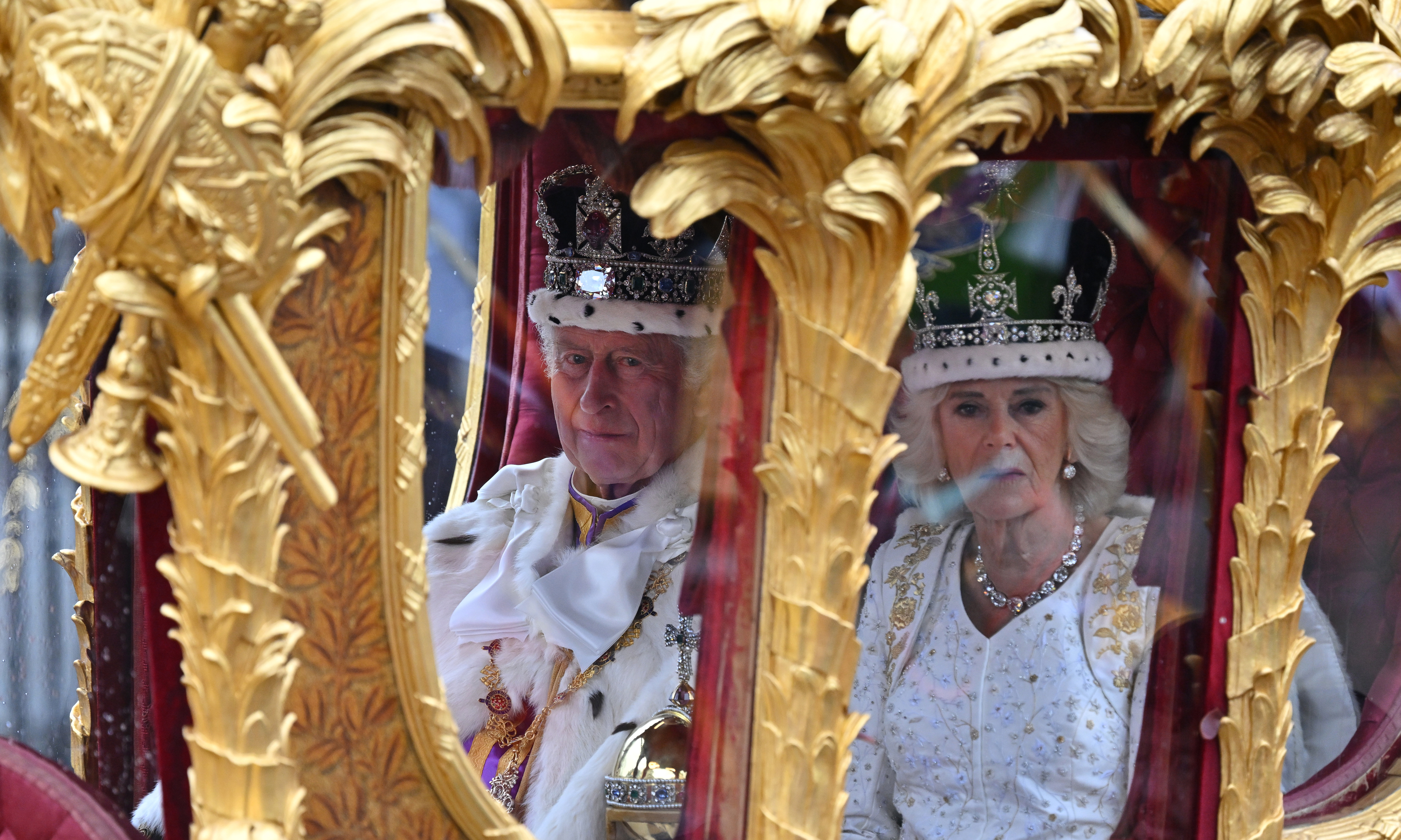 Britain’s King Charles III and Britain’s Queen Camilla travel in the Gold State Coach, built in 1762, back to Buckingham Palace from Westminster Abbey in central London on May 6, 2023, after their coronations.