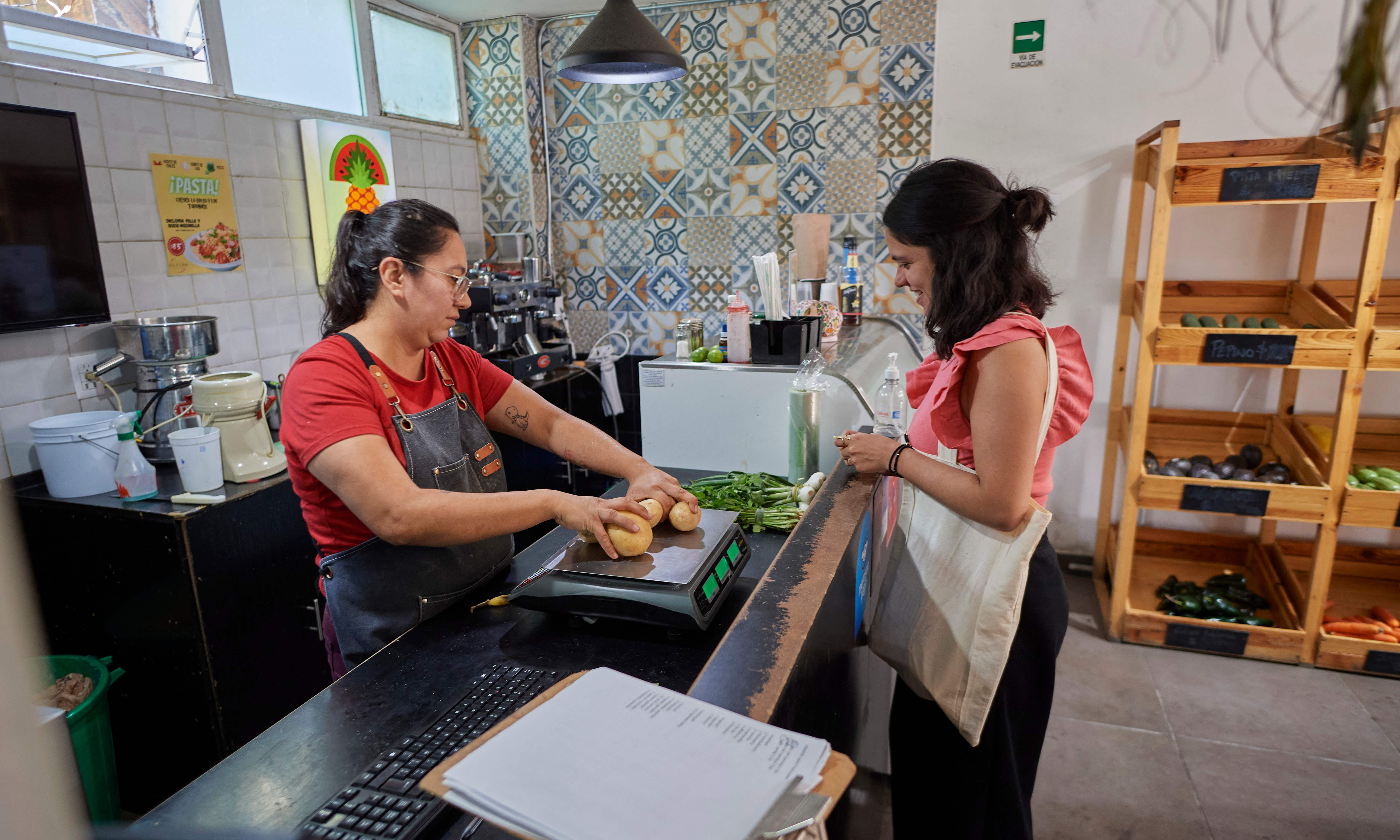 Venezuelan migrant Laura Linares buys vegetables to prepare turmada, a Venezuelan Andean dish.