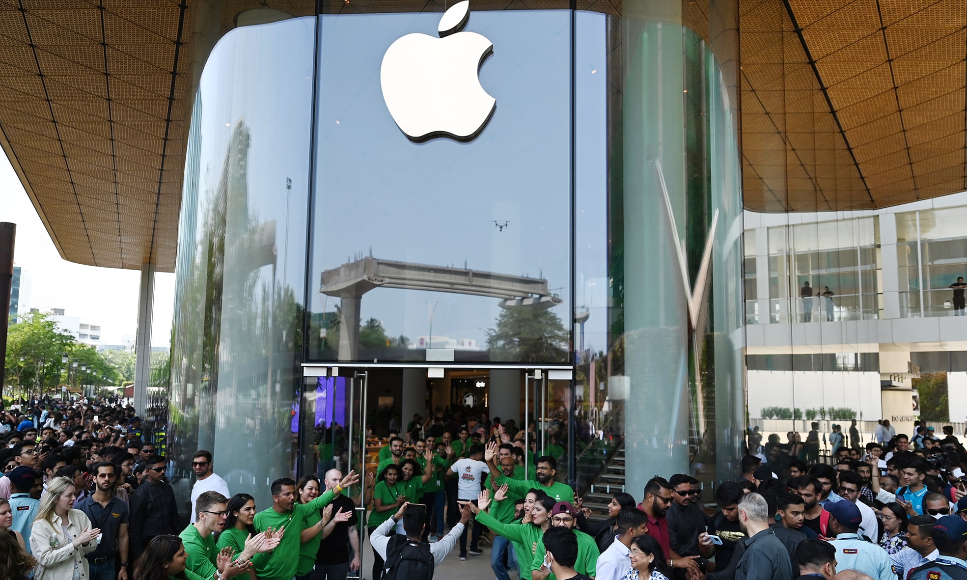 MUMBAI: In this file photo taken on April 18, 2023 Apple employees (in green) cheer as they welcome customers during the opening of Apple's first retail store in India, in Mumbai. – AFP