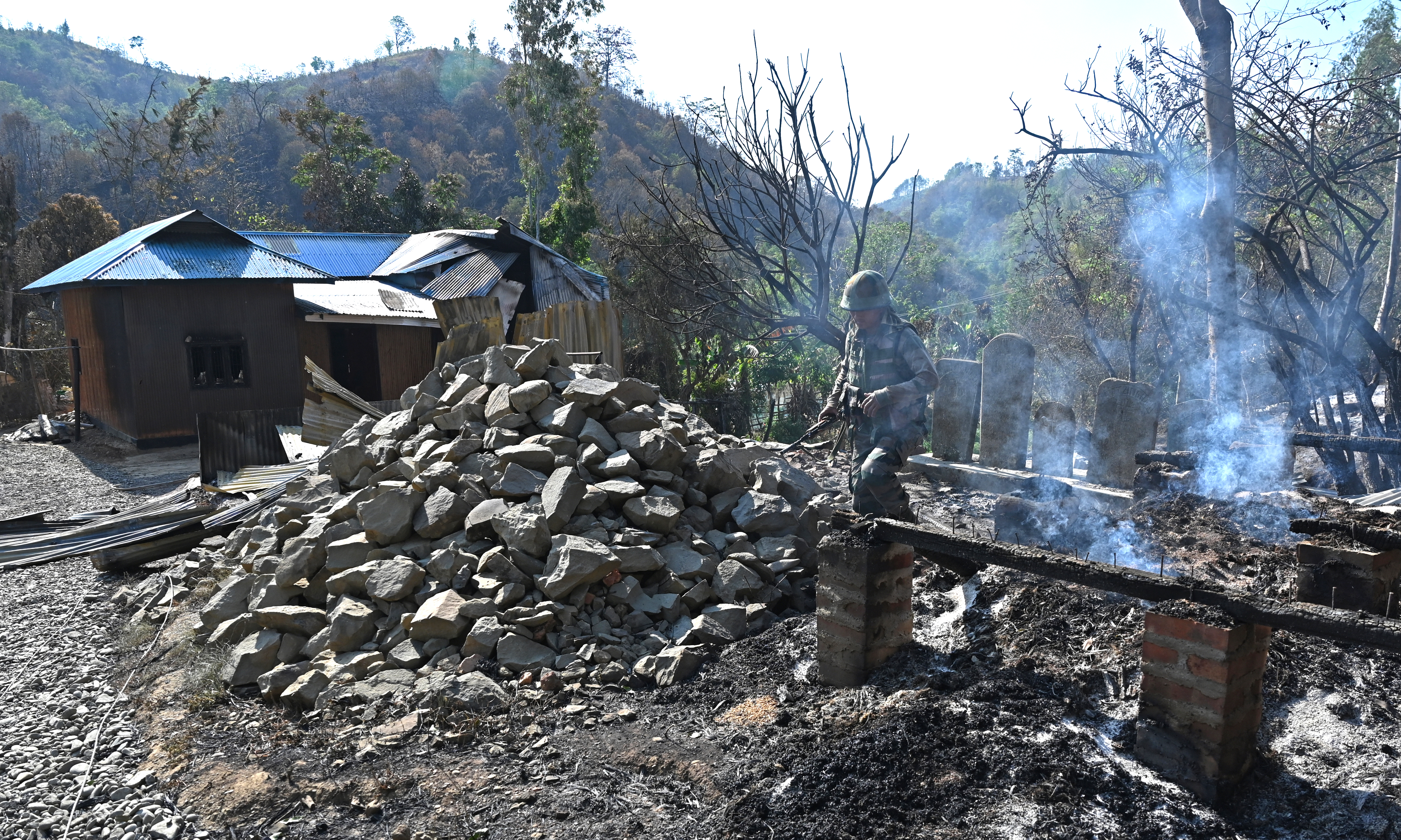 SENAPATI: An Indian army soldier inspects the remains of a house that was set on fire by a mob in the ethnic violence hit area of Heiroklian village in Senapati district, in India's Manipur state. – AFP