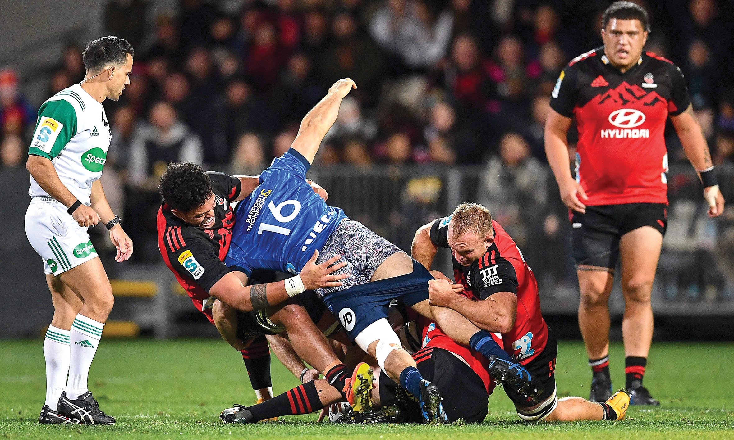 Blues' Kurt Eklund (C) gets tackled by the Crusaders' defence during the round 12 Super Rugby Pacific match between Crusaders and Blues at Orangetheory Stadium in Christchurch on May 13, 2023. (Photo by Sanka Vidanagama / AFP)
