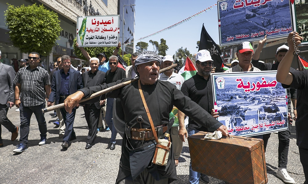 RAMALLAH: A protester carries luggage symbolising Palestinians who fled or were expelled from their homes 75 years ago during a rally marking 'Nakba' day in the Ramallah city center in the occupied West Bank. – AFP