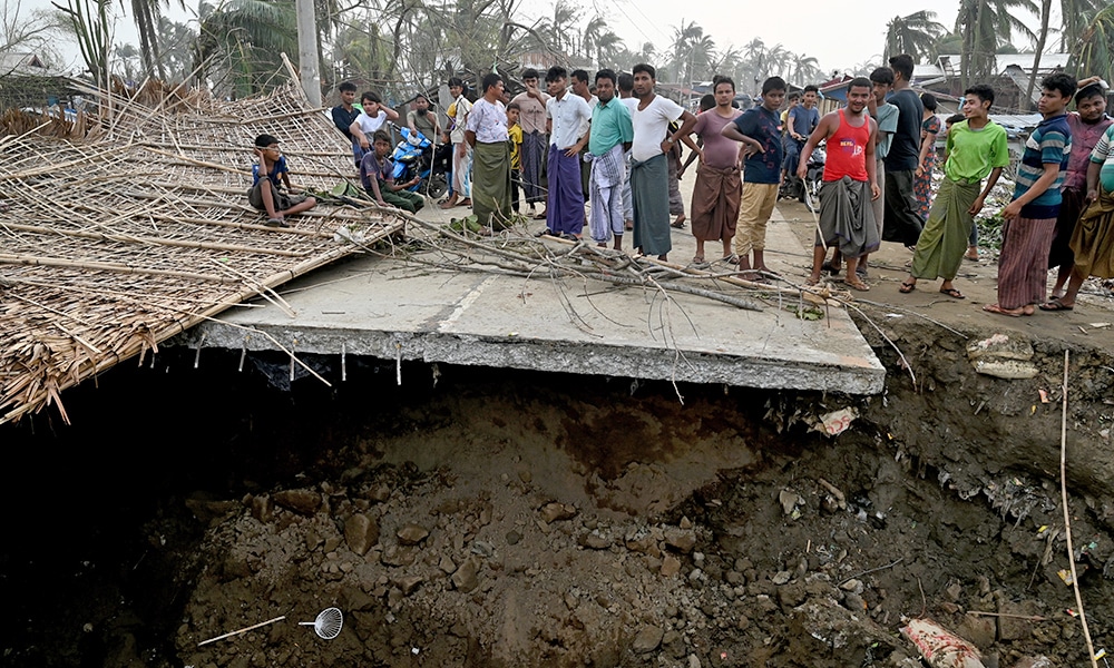 SITTWE: Local residents stand on a broken bridge at the Khaung Dote Khar Rohingya refugee camp in Sittwe, on May 15, 2023, after cyclone Mocha made a landfall. – AFP