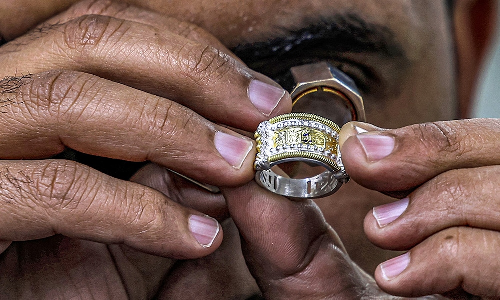 A smith uses a loupe magnifier to inspect a jewellery piece at the Azza Fahmy workshop.