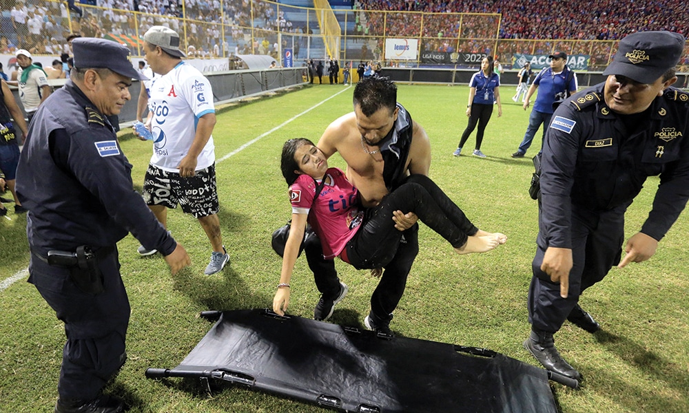 SAN SALVADOR: Supporters are helped by others following a stampede during a football match between Alianza and FAS at Cuscatlan stadium in San Salvador. – AFP