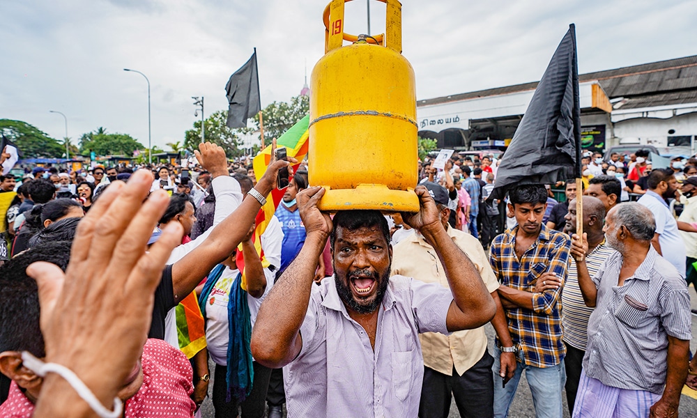 A man lifts a gas tank amid fuel shortages and an ongoing economic crisis as he joins a protest to demand the resignation of President Gotabhaya Rajapakse in Colombo, Sri Lanak, on June 30. Thilina Kaluthotage/NurPhoto via Getty Images