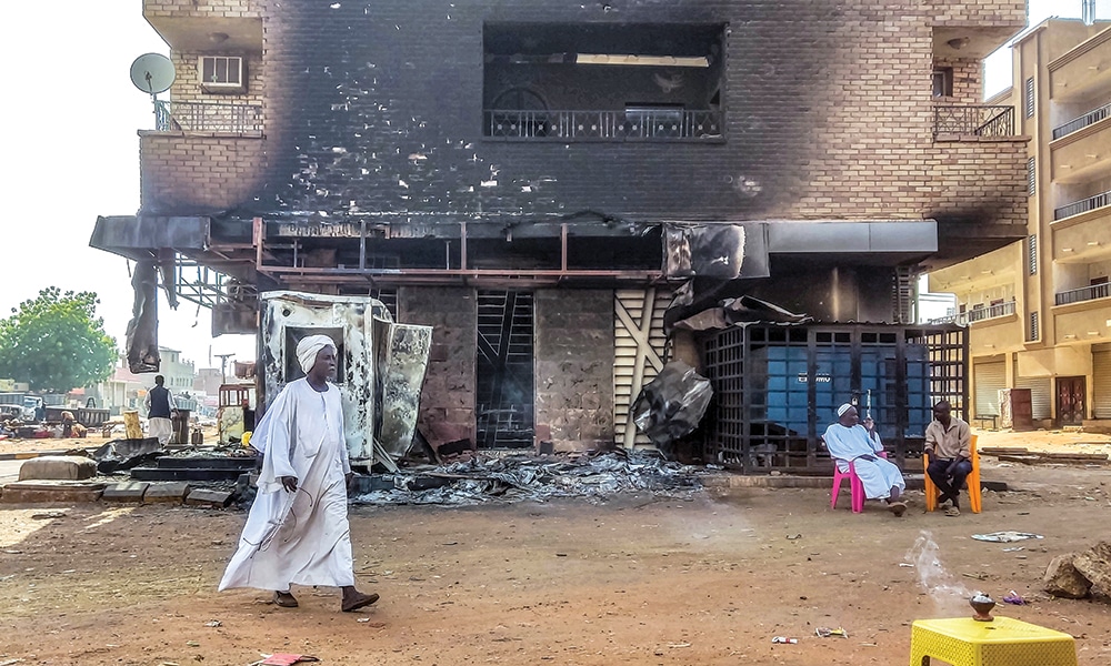 KHARTOUM: A man walks past a burnt out bank branch in southern Khartoum on May 24, 2023. – AFP