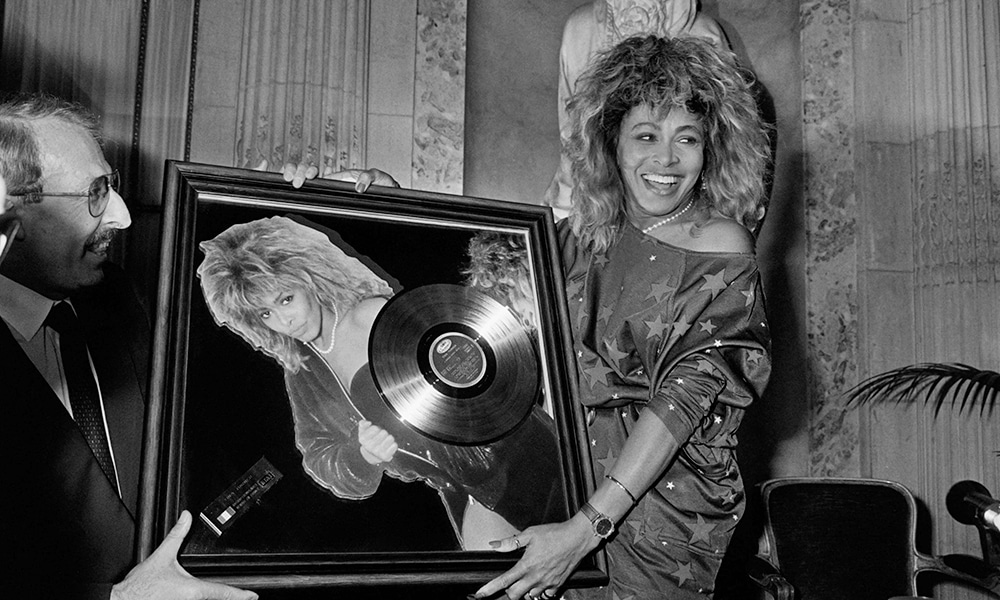 US singer Tina Turner receives the Golden record award from Pathe Marconi chairman Guy Deluz (left) on October 8, 1986, in Paris.