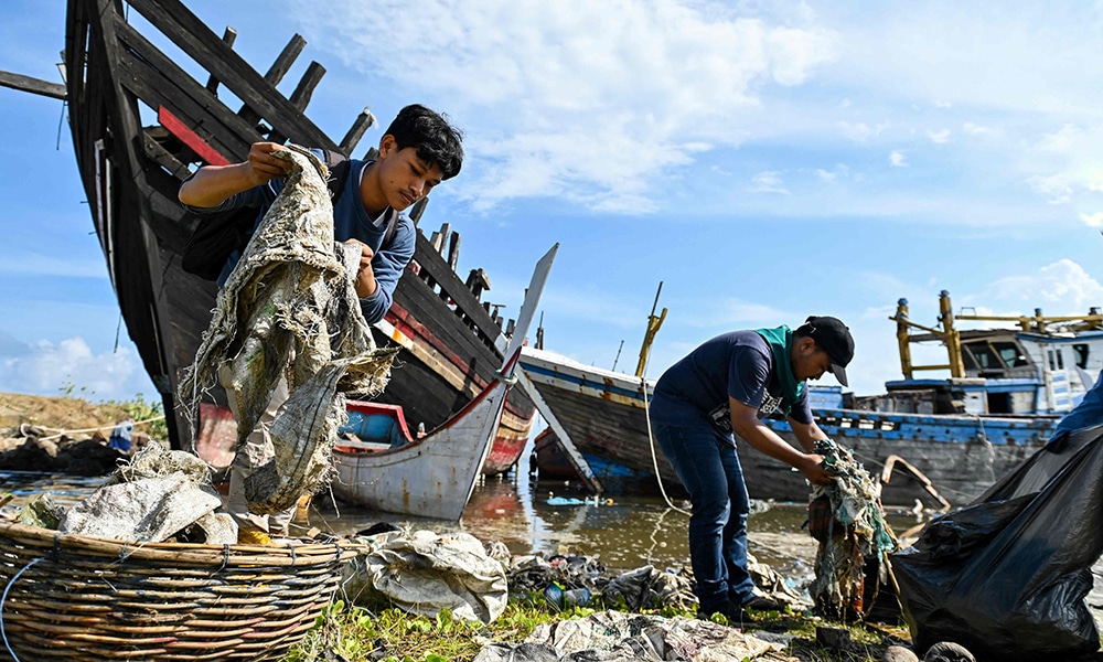 BANDA ACEH, Indonesia: University students clean up plastics and other debris washed ashore at a port on May 21, 2023. – AFP