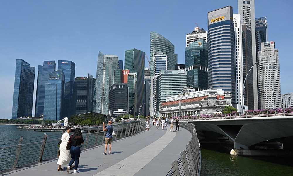 SINGAPORE: People walk across Jubilee Bridge on Marina Bay in Singapore on May 25, 2023. – AFP