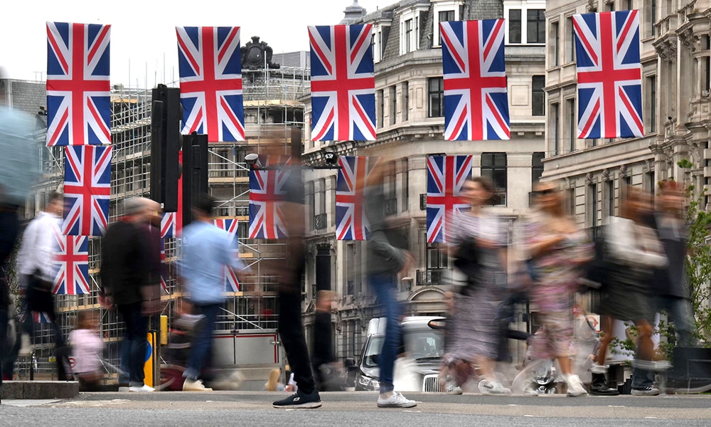 LONDON: Pedestrians walk past Union flags at Oxford Circus on May 25, 2023. – AFP