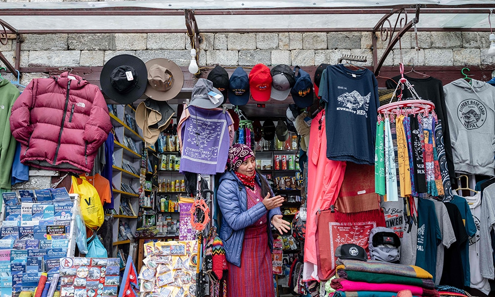 This picture shows a shopkeeper standing at the entrance to her store in the town of Namche Bazaar, often dubbed as a gateway to Everest.