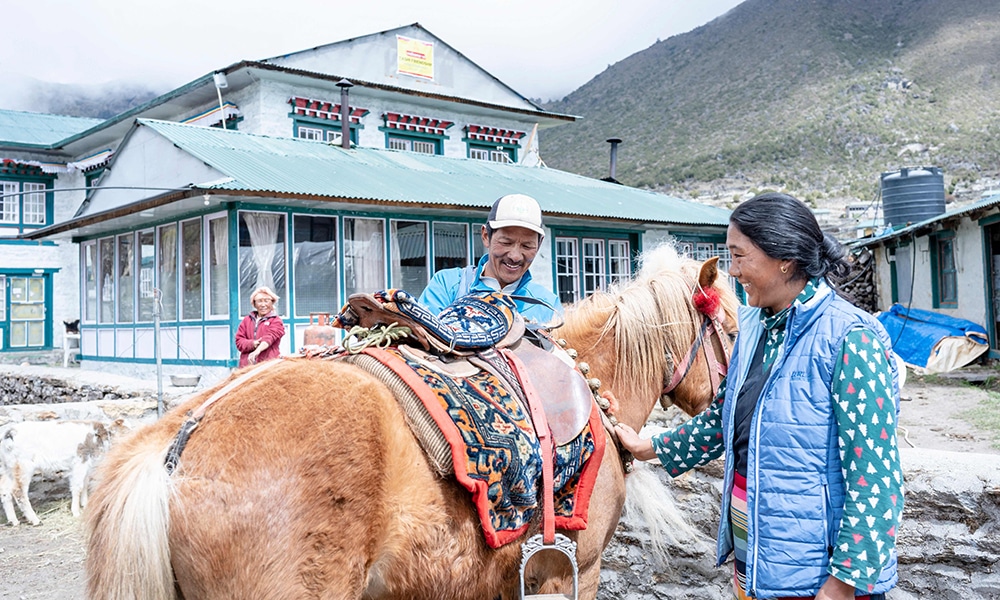 Phurba Tashi Sherpa (left), head of an expedition operator and guide, and his wife as they prepare his horse for a ride during an interview with AFP at the village of Khumjung.