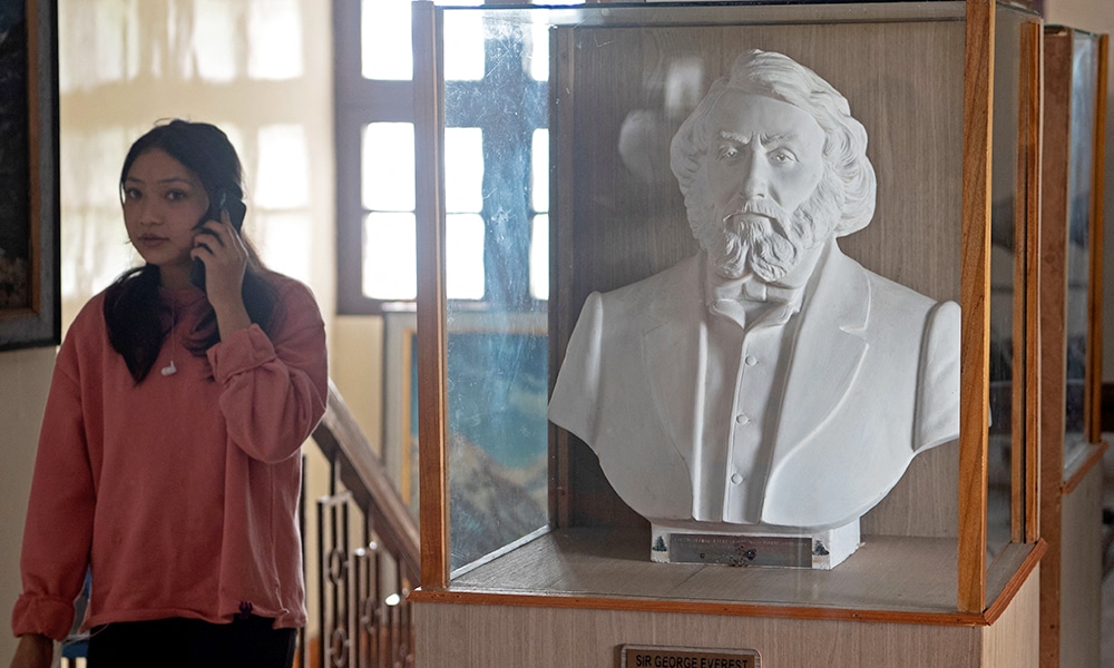 A tourist walks past a sculpture of British surveyor and geographer, late Sir George Everest at the Himalayan Mountaineering Institute museum, in Darjeeling.