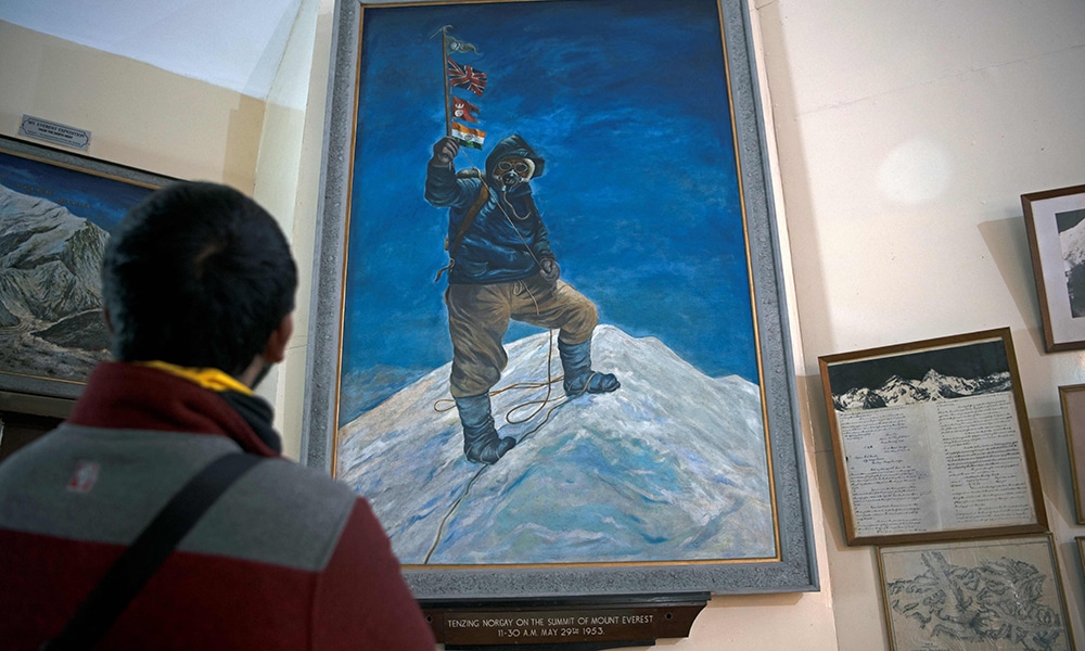 In this photograph taken on May 20, 2023, a painting of late mountaineer Sherpa Tenzing Norgay's Everest summit is on display at the Himalayan Mountaineering Institute museum, in Darjeeling. When Edmund Hillary and Tenzing Norgay Sherpa first climbed Everest 70 years ago on Monday, they paved the way for thousands of foreign climbers to try to follow in their footsteps. And the eight-day trek to the Everest base camp is among the most popular multi-day hikes in Nepal, with tens of thousands of tourists making the journey every year. (Photo by Jalees ANDRABI / AFP) / TO GO  WITH: Nepal-mountaineering-Everest-economy-tourism, FOCUS by Paavan MATHEMA