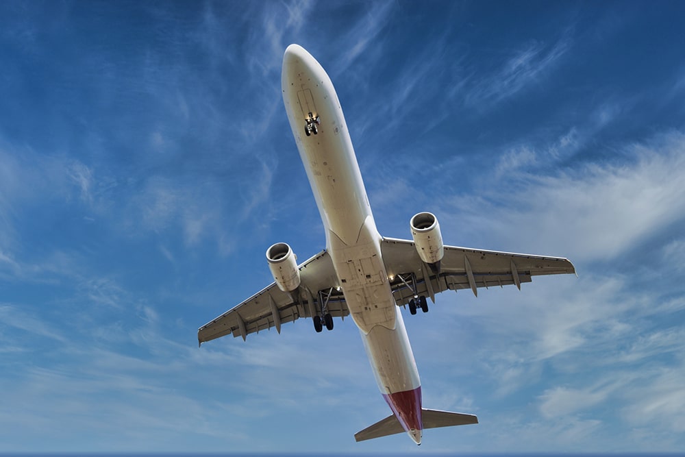 Stock photo of big plane before landing, flying in blue sky.