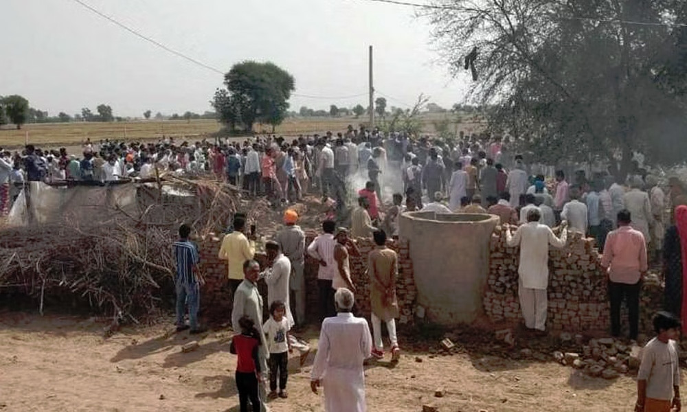 Locals gather after a MiG-21 fighter aircraft of the Indian Air Force (IAF) crashed in Hanumangarh district, Monday, May 8, 2023.