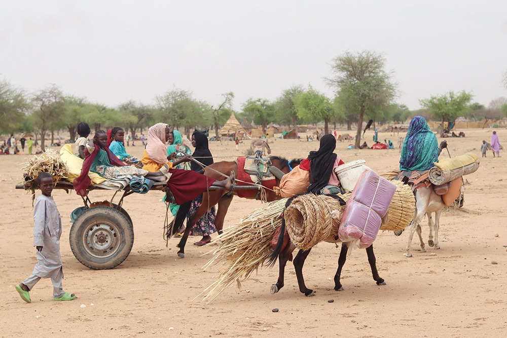 KOUFROUN: Sudanese refugees cross into Chad near Koufroun, Echbara. Hundreds of Sudanese, most of them women and children, each day cross a small, dry stream to find safety in neighbouring Chad. – AFP
