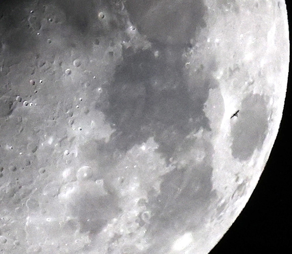 The International Space Station (ISS) transits the waxing gibbous moon as seen from Kuwait City, on May 28, 2023.