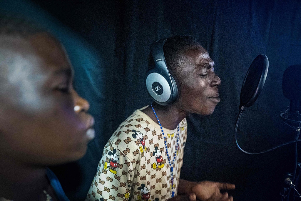 Junior 'Des Affaires' (right) and Obed 'Banque de Sang' (left) rap in the recording studio of the cultural centre Mokili na Poche in Kinshasa.-- AFP photos